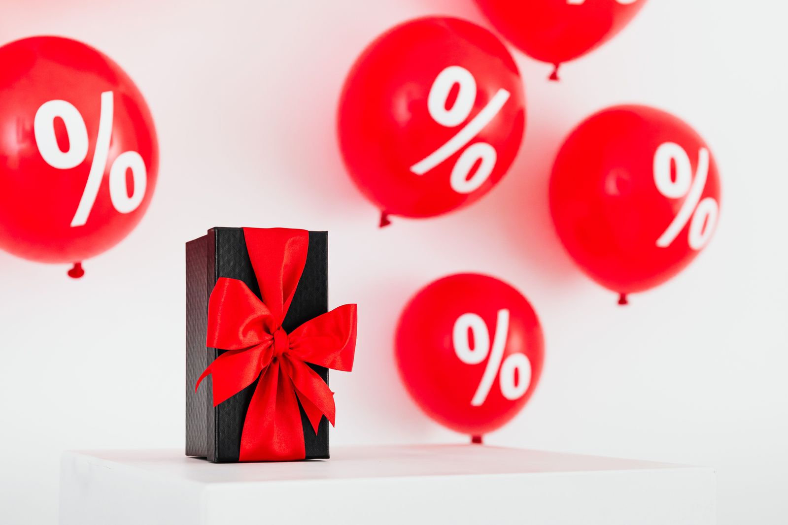 Cadeau emballé entouré de ballons pourcentage
