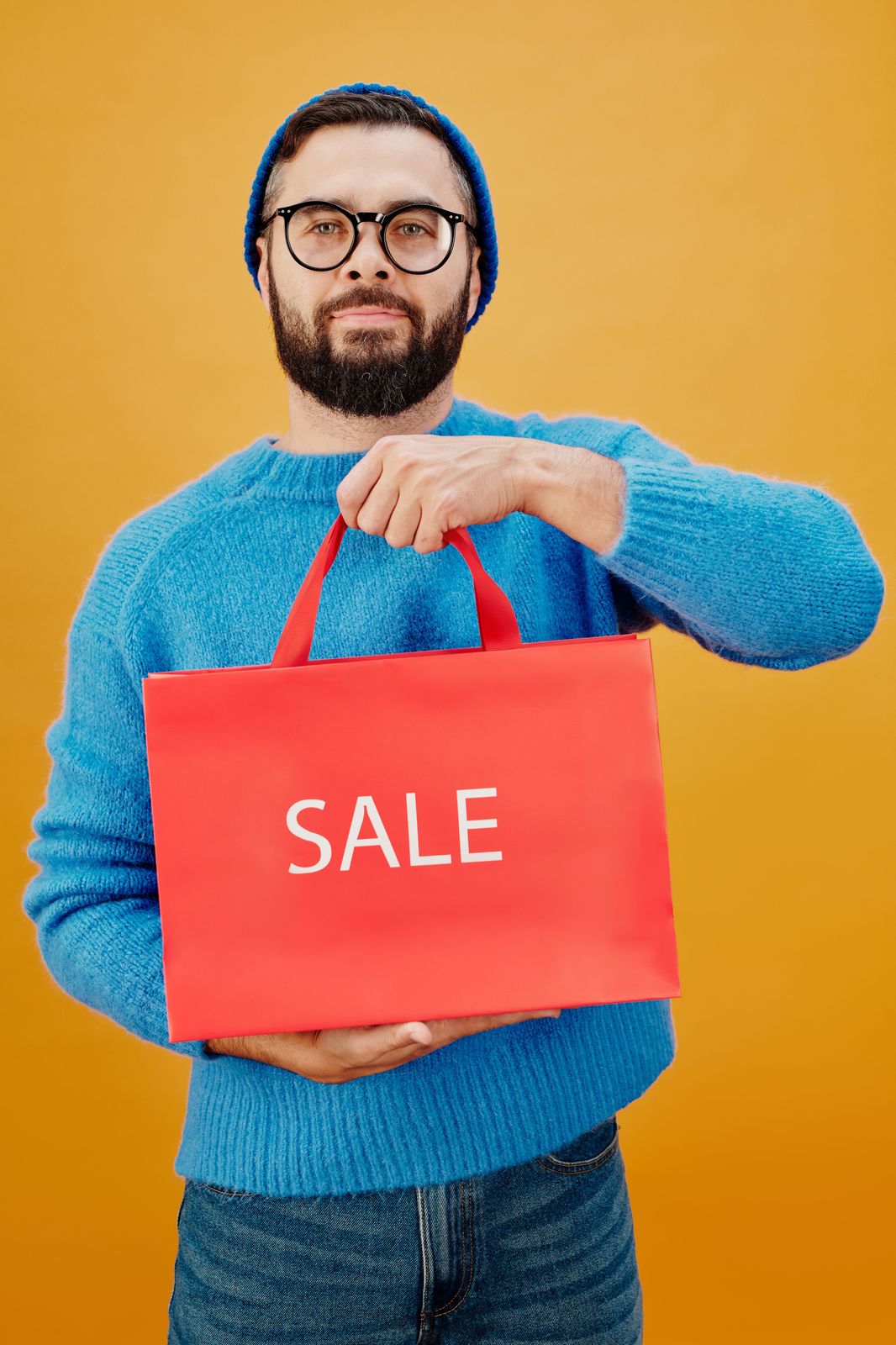 Homme tenant un sac shopping rouge Sale